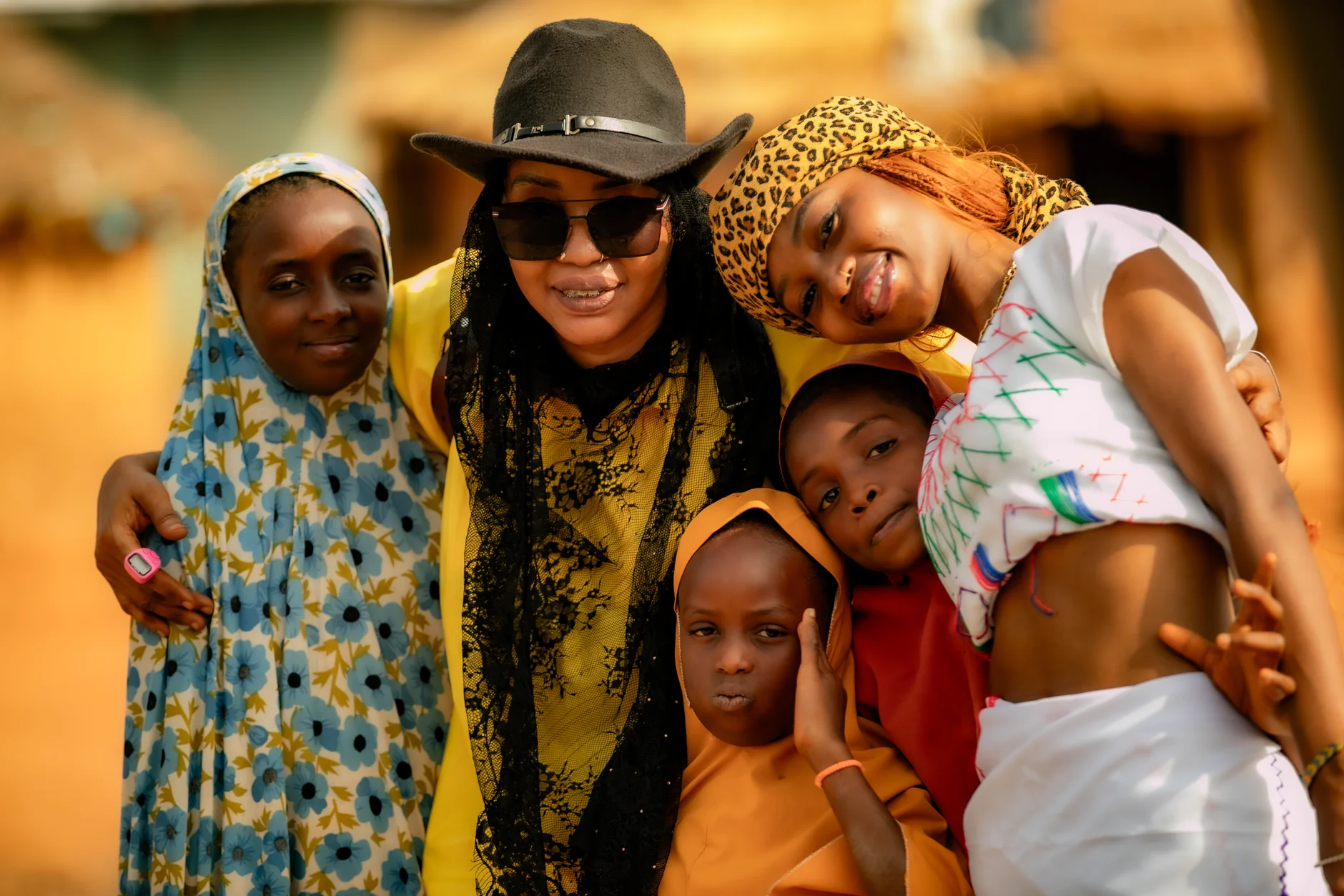 Group of diverse African friends embracing and smiling outdoors. Community and joy.