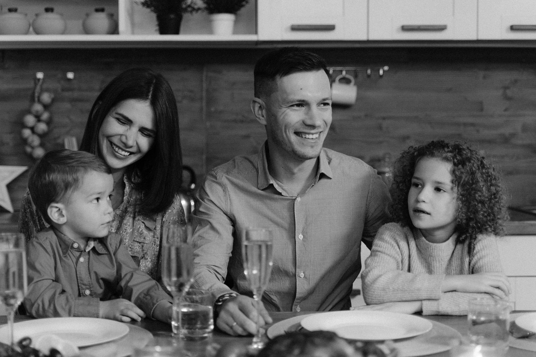 Smiling family enjoying quality time together at dining table in cozy kitchen.